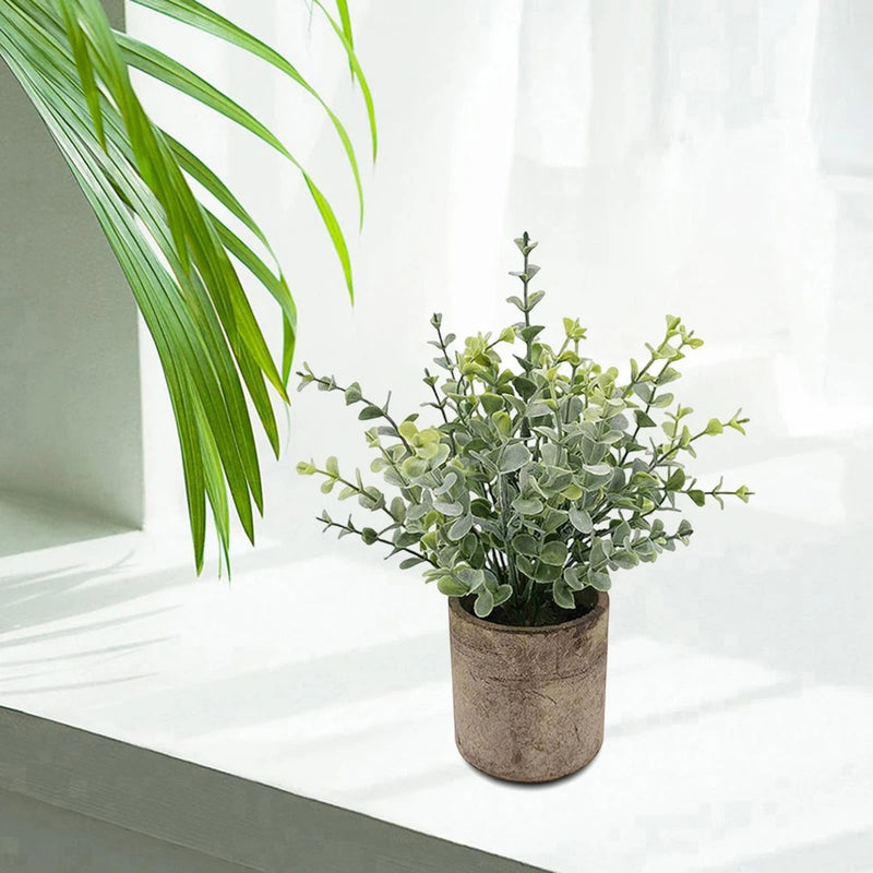 Artificial mini potted greenery plant with green faux leaves in textured fabric pot