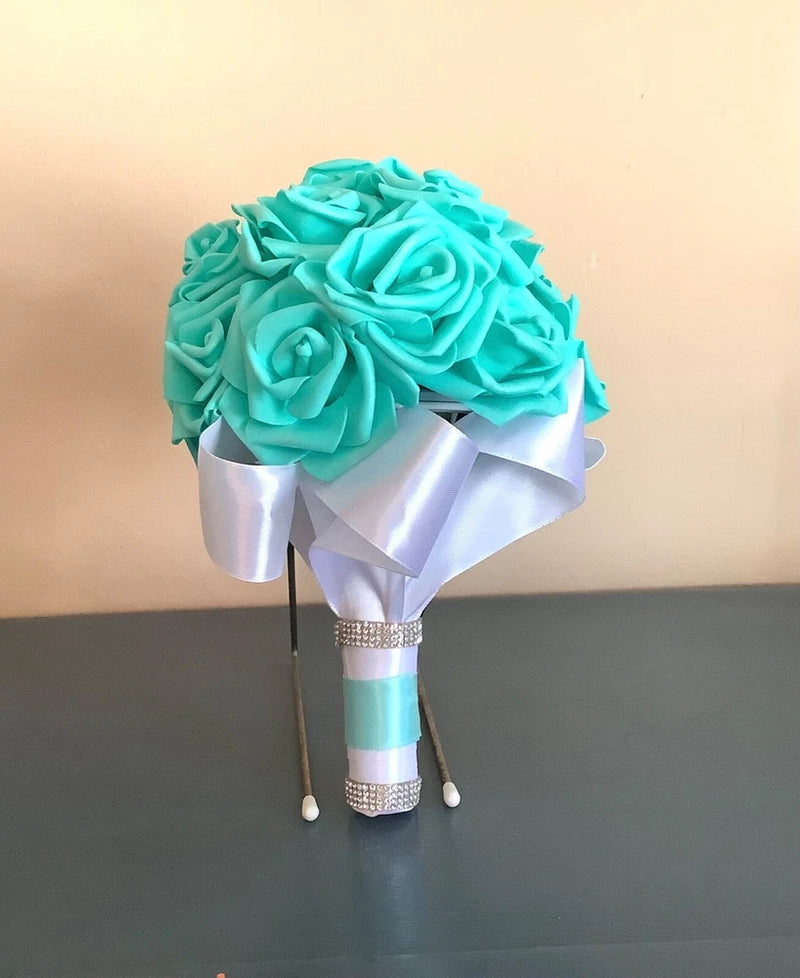 Small teal rose bridal bouquet with white satin ribbons and beaded handle