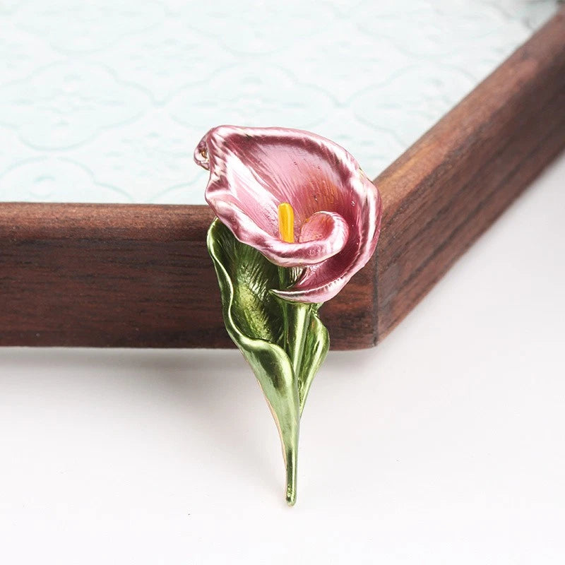 Enamel calla lily brooch with pink petals and yellow center, gold-toned pin