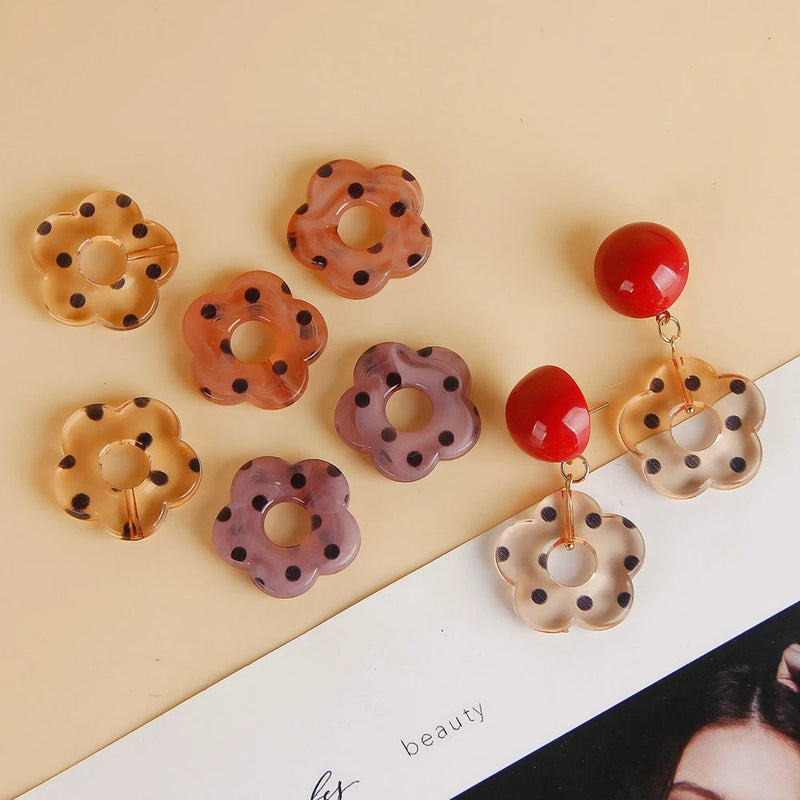 Set of hollow flower pendants with ring hooks in orange, purple, and cream, polka-dot style