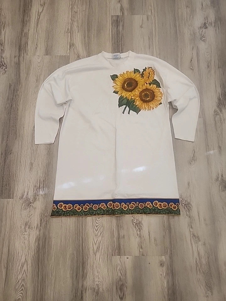 White long tunic blouse with embroidered sunflower motif on chest and hem trim