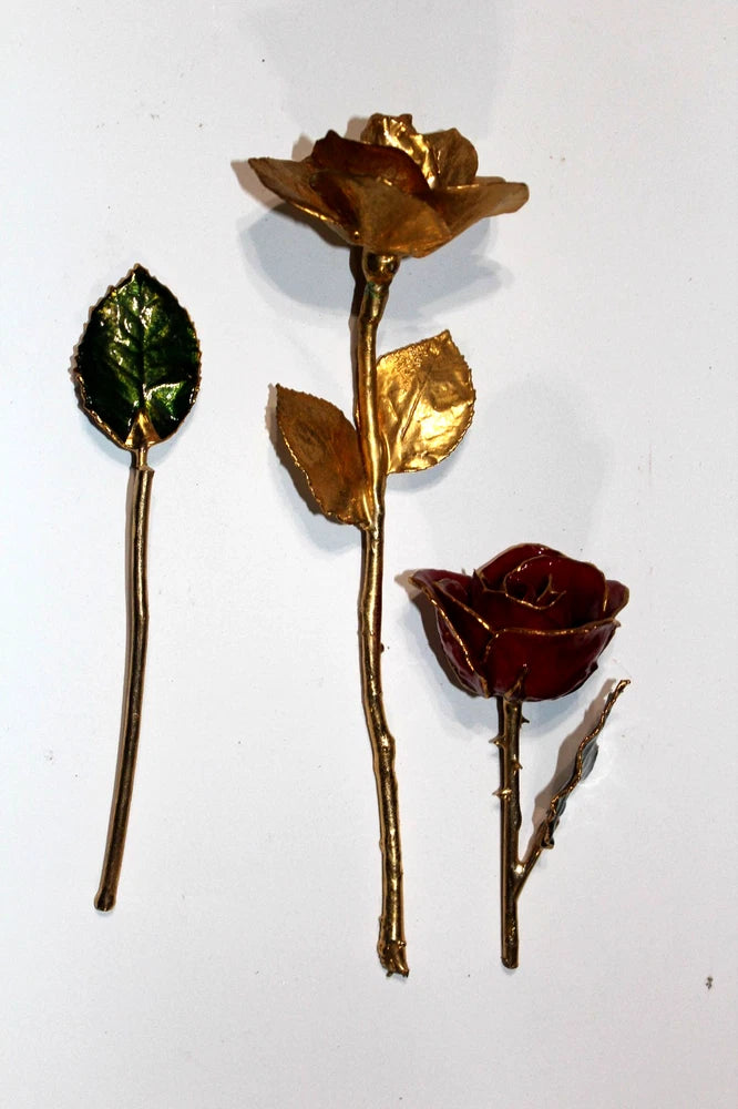 Gold tone rose and leaf accents with red flower on slender metal stems