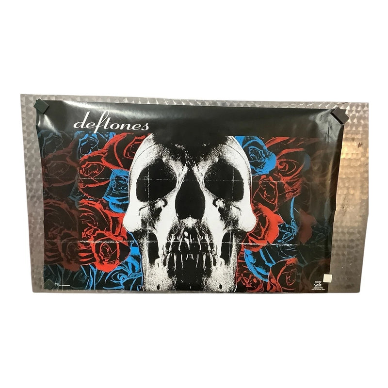Vintage Deftones poster with skull face and colorful roses, folded in plastic