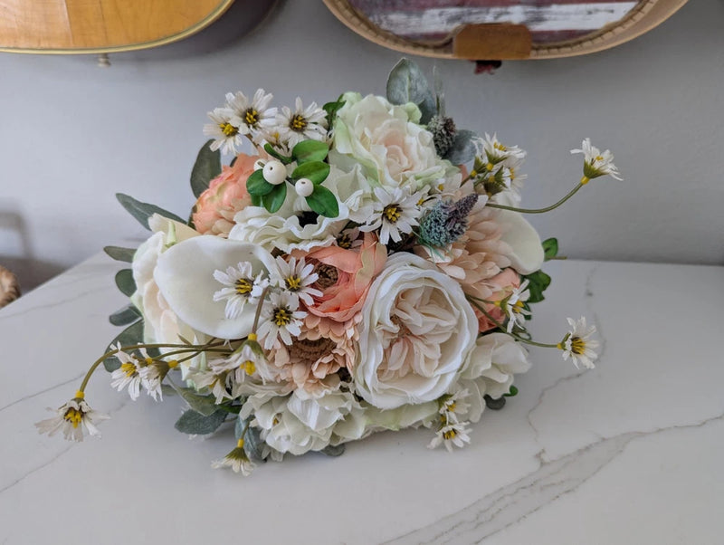 Artificial bridal bouquet with peach and white roses, small daisy blooms, and green leaves