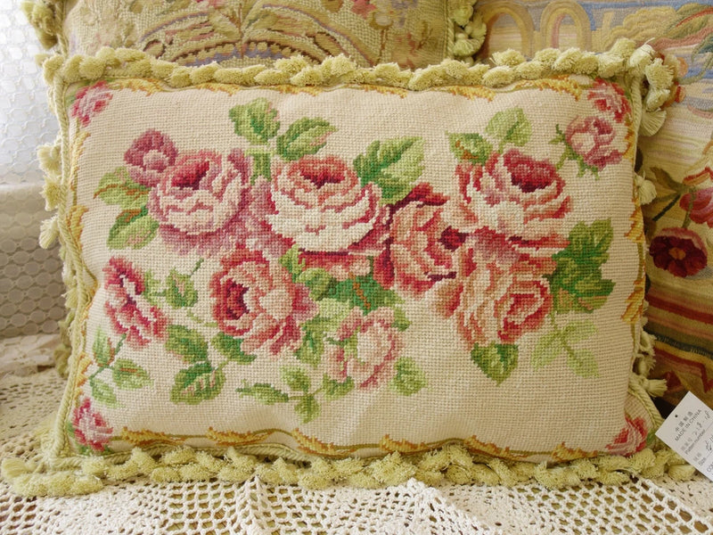 Handcrafted needlepoint pillow cover with red rose floral design and cream fringe trim