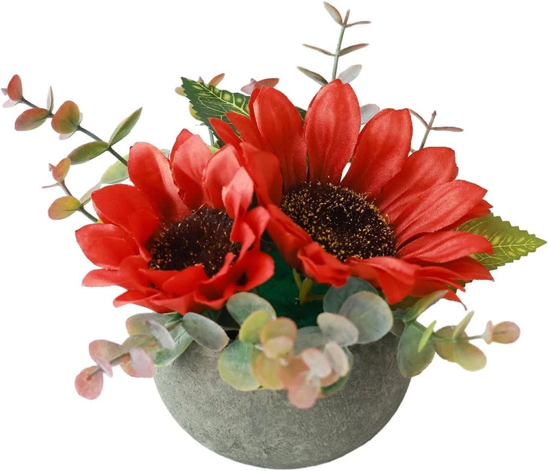 Artificial red sunflower arrangement in gray pot with green leaves and stems
