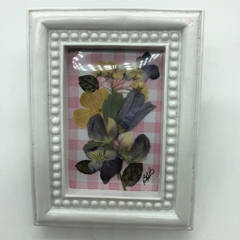 Framed dried flower picture with light gray beaded border and pressed floral arrangement