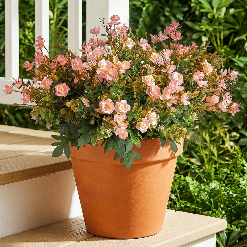 Pink faux mini rose artificial flowers in terracotta pot with green faux leaves