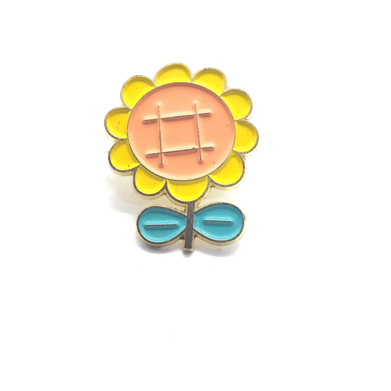 Sunflower enamel lapel pin with yellow petals and orange center, teal leaf accents