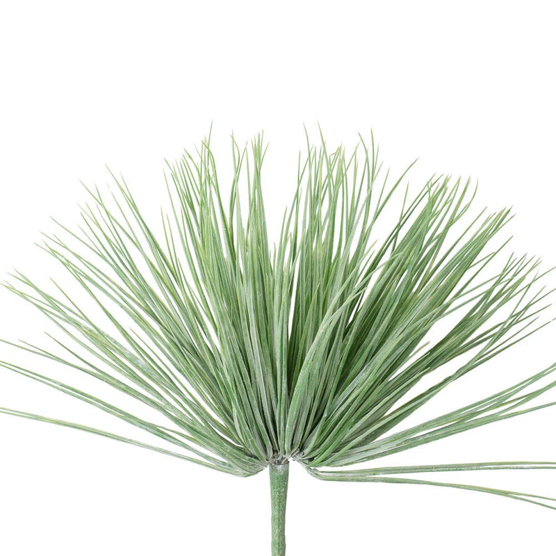 Artificial grass bush with long green blades on a short gray stem