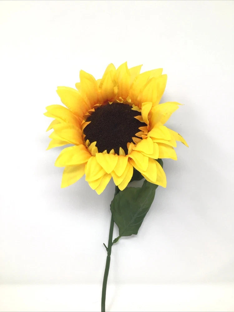 Large artificial sunflower pick with yellow petals, dark center, and green stem with leaf