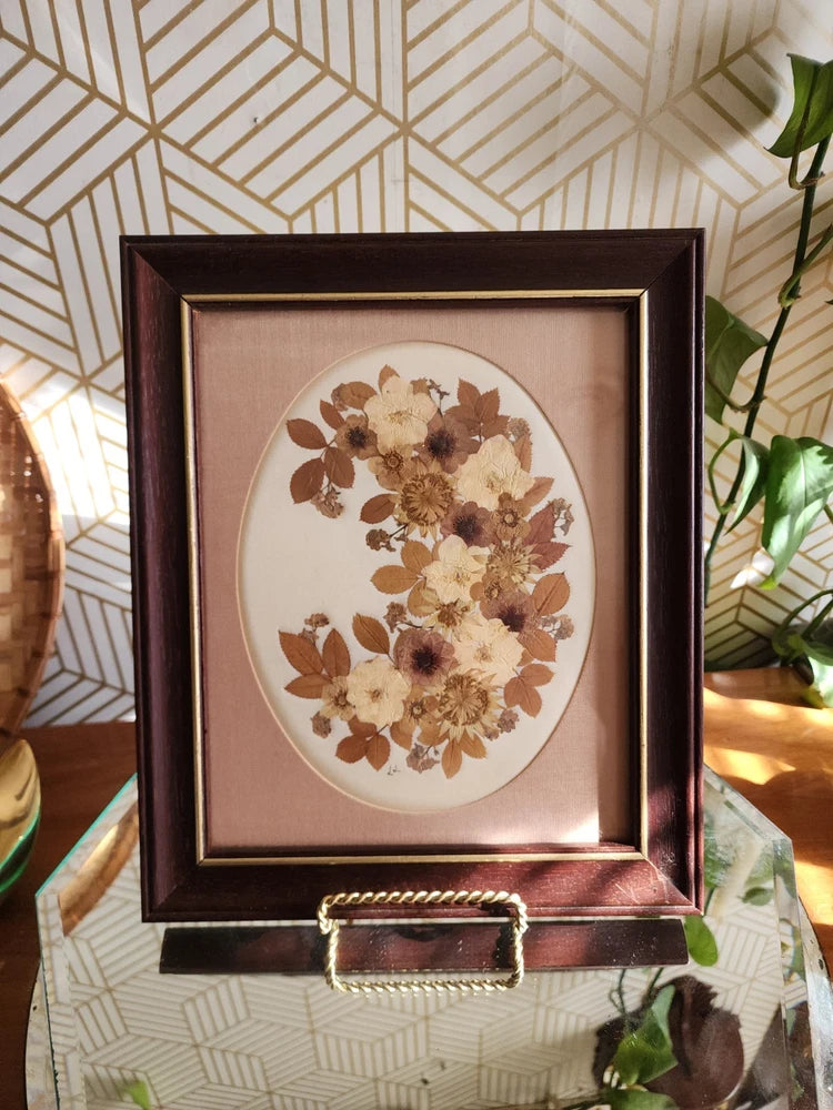 Framed dried wildflower arrangement with oval mat and dark wood-style frame
