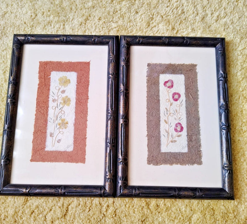 Set of 2 framed botanical pressed flower wall art prints, each with floral detail.