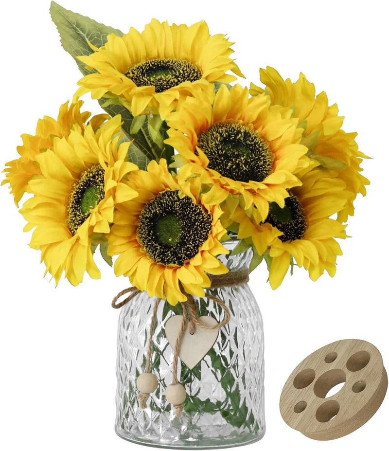 Artificial yellow sunflower bouquet with green leaves in clear glass vase and wooden lid