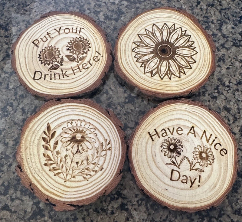 Set of 4 round pine wood coasters with laser-engraved sunflower designs and quotes