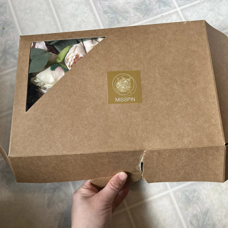 Artificial peony flower bouquet in kraft gift box, open corner shows cream blossoms