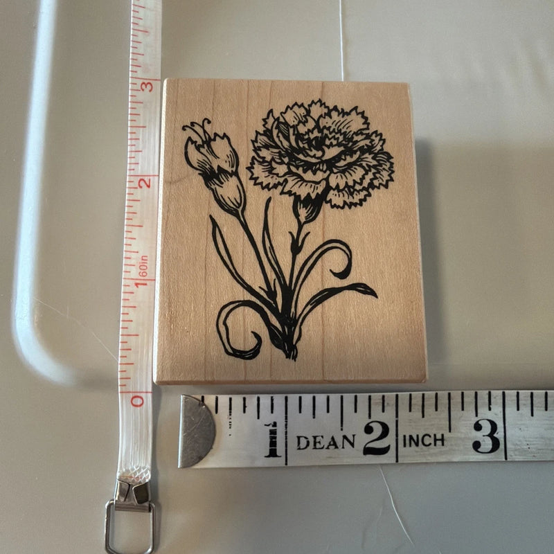 Carnation rubber stamp with black flower outline on square wooden block