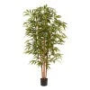 Artificial bamboo plant in pot with slender green stalks and leafy branches