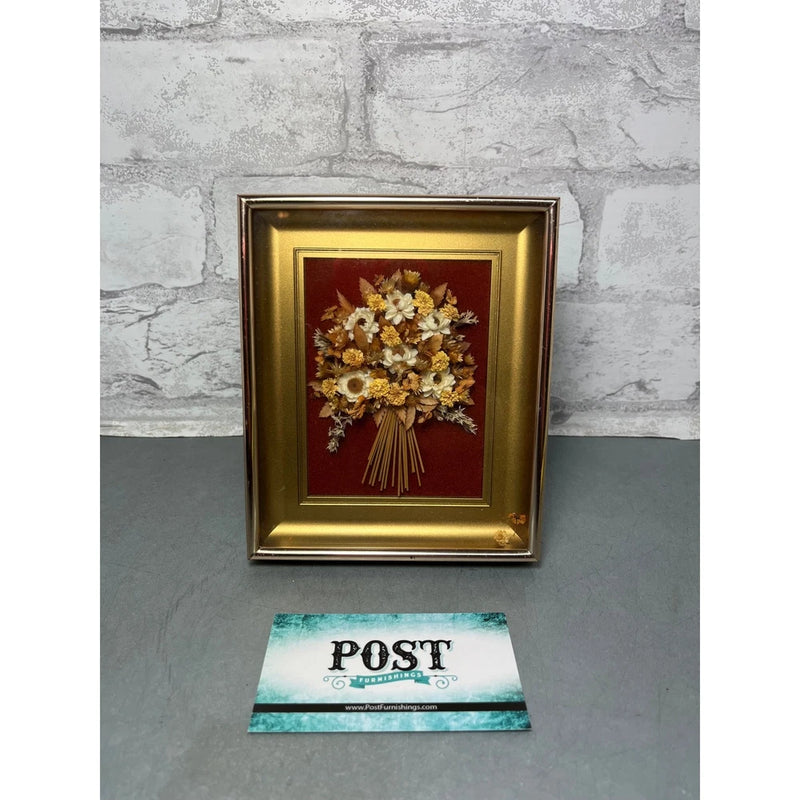 Gold framed shadow box wall art with dried flower bouquet on red backing