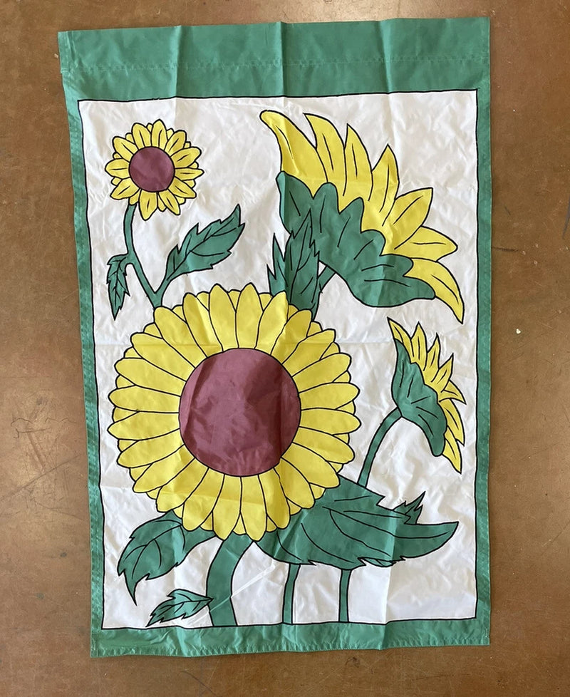 Sunflower flag with green border, white field, large yellow sunflower and green leaves