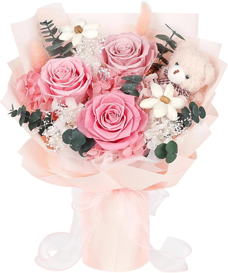 Pink preserved rose bouquet with white flowers, green leaves, and plush bear