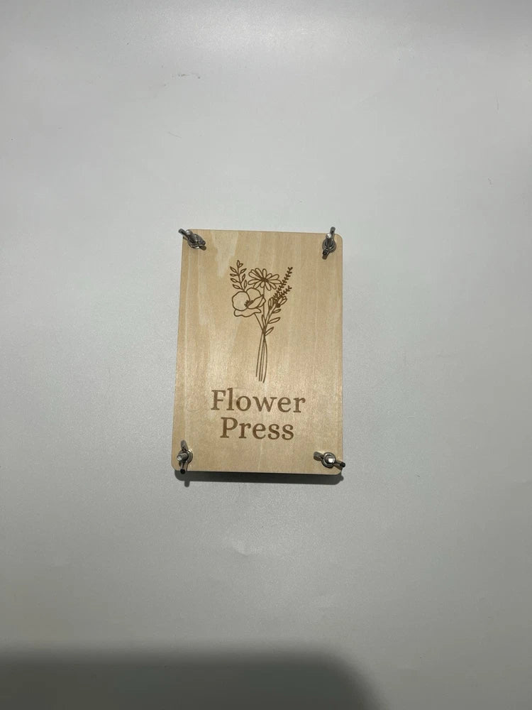 Wooden flower press with illustrated cover and metal corner clamps