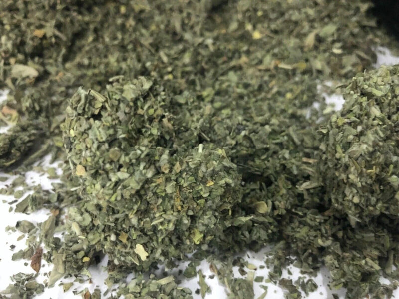 Dried organic herb leaves, finely chopped green leaf pieces pile