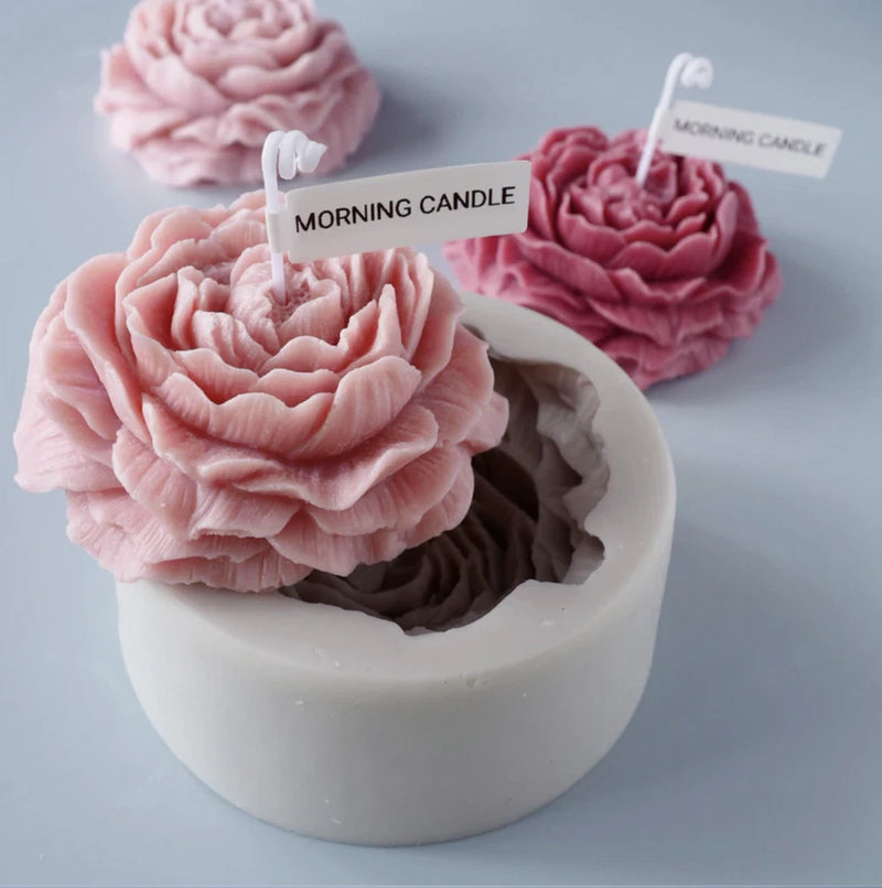 Pink peony flower candle set in white cylinder silicone mold with wick label 'MORNING CANDLE'.