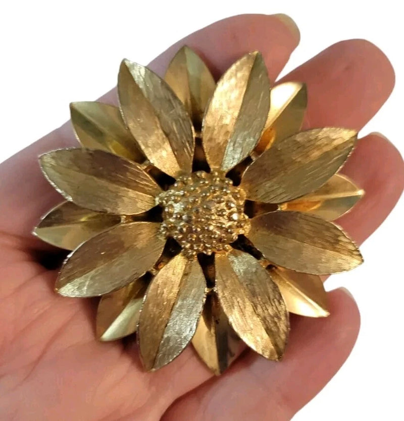 Goldtone sunflower brooch with textured center and layered petal details