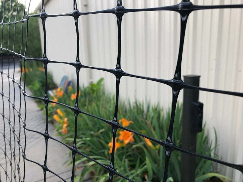 Black plastic garden climbing net trellis with square grid openings