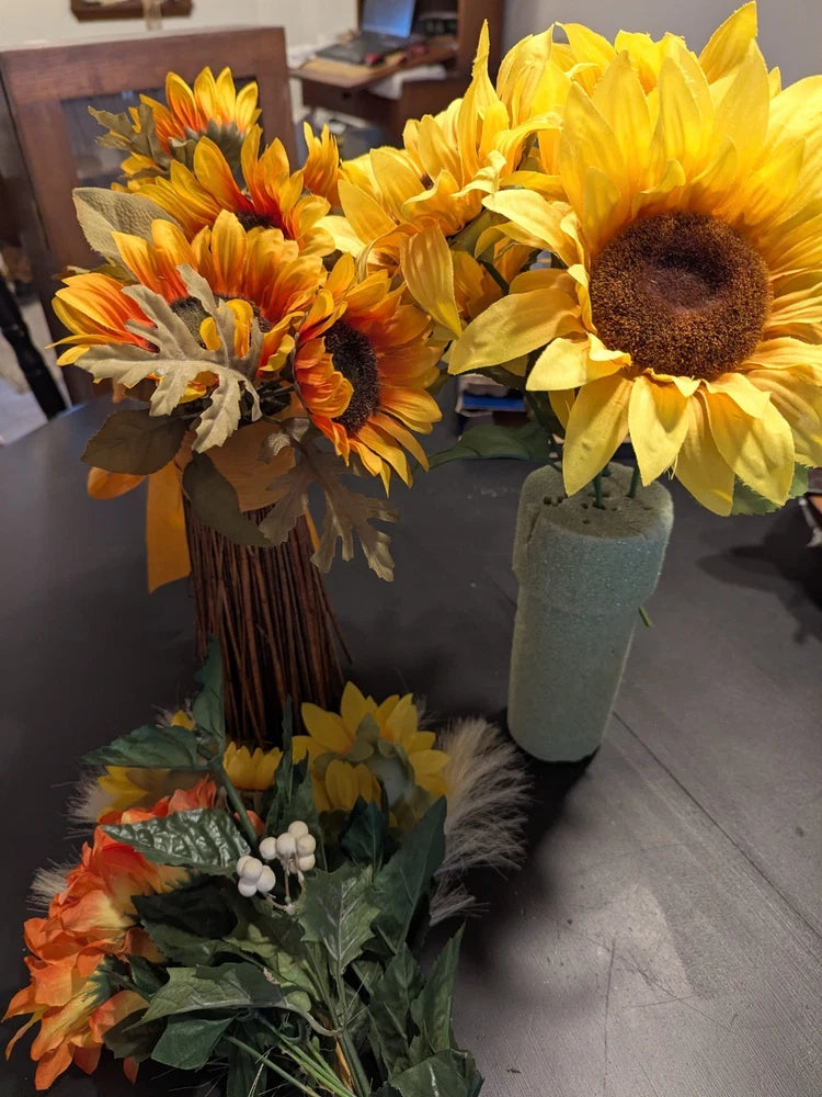 Set of floral sunflowers in small vases with green leaves
