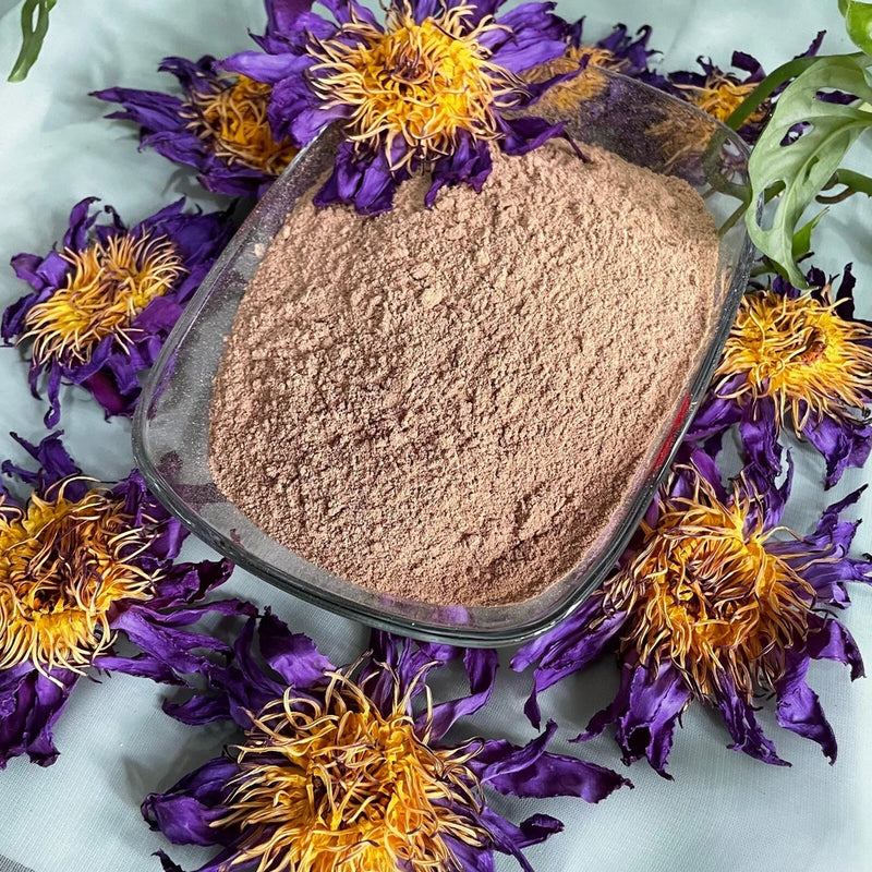 Organic herbal tea flower powder in metal scoop with dried petals around
