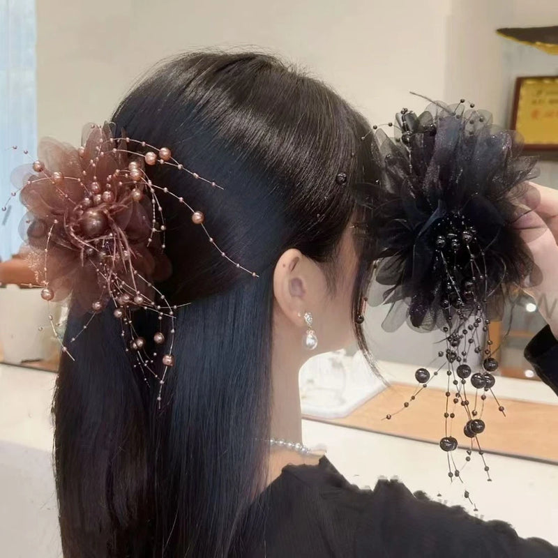 Two flower hairpins, blush pink and dark gray, with pearl bead strands and dangling charms