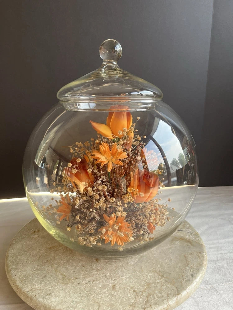 Glass cloche terrarium with orange dried flowers inside clear globe