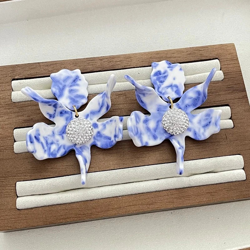 Blue and white resin lily flower drop earrings with round rhinestone centers