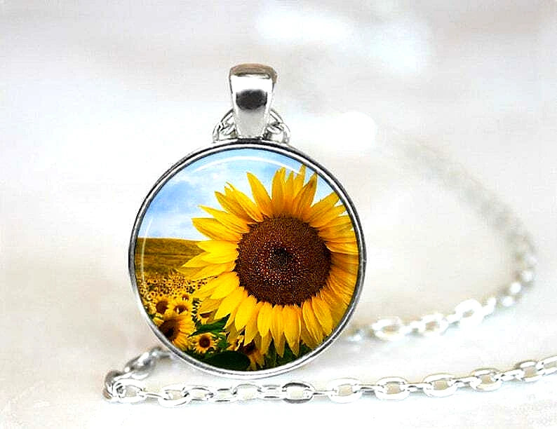 Sunflower pendant necklace with round silver setting and bright yellow flower on glass