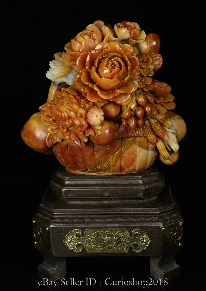 Orange carved peony flower sculpture in a pot on a dark pedestal base