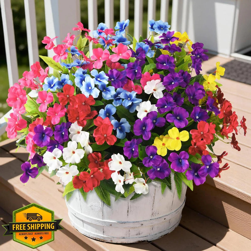 Multicolor artificial impatiens flowers with green leaves in white planter pot