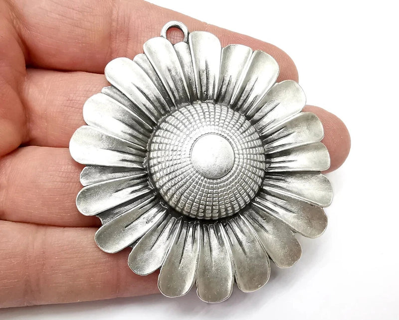 Antique silver sunflower flower pendant with textured center and scalloped petals.
