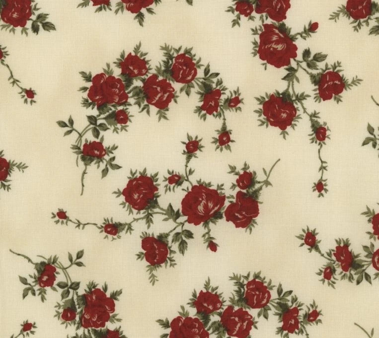 Cream cotton fabric with scattered red roses and small floral sprigs pattern