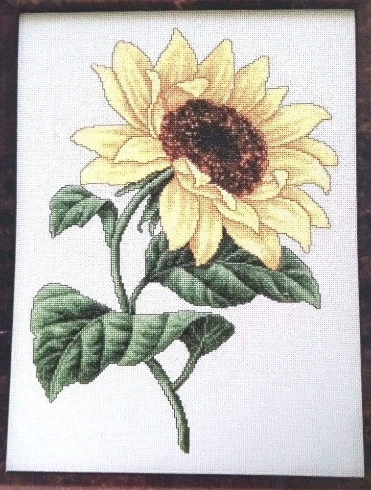 Sunflower cross stitch pattern featuring yellow petals, dark center, and green leaves