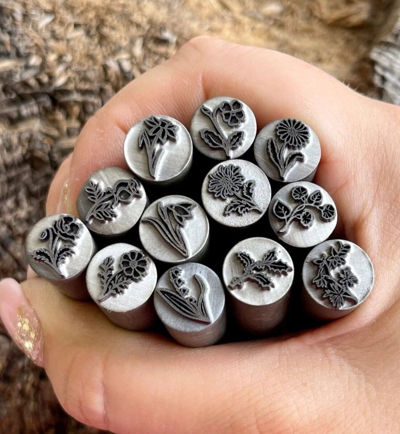 Metal stamping punch set with raised lily and floral motifs, round steel dies in hand