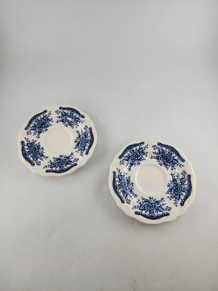 Set of two blue-and-white floral ceramic saucers with scalloped rims