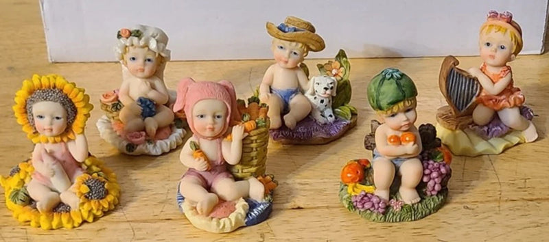 Set of 6 garden figurines: children figures with dog, flowers, fruit, and hat details