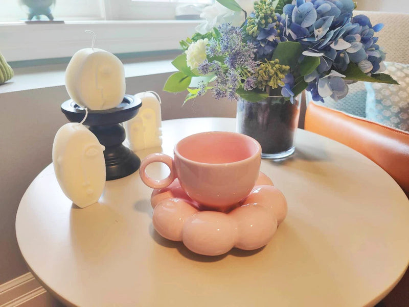 Pink ceramic cloud-shaped mug on matching saucer