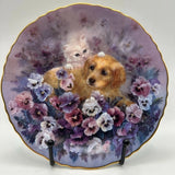 Decorative collector plate with two puppies nestled in pink and purple flowers, gold rim
