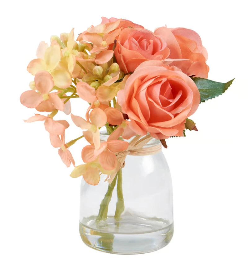Clear glass vase with peach and pink roses bouquet