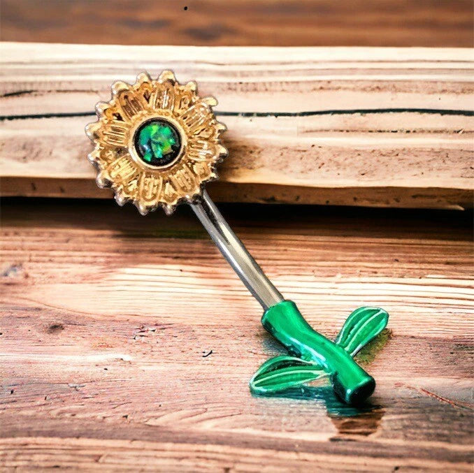 Gold-tone sunflower belly ring with green faux opal center and curved bar