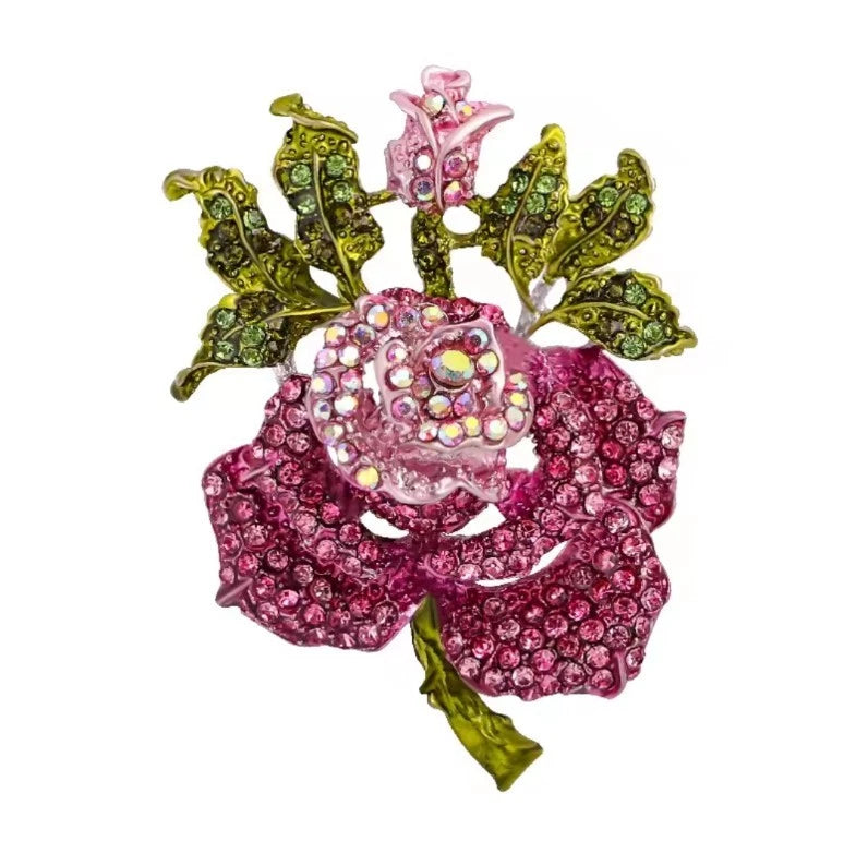 Pink rose flower brooch with multicolored rhinestones and green leaf accents