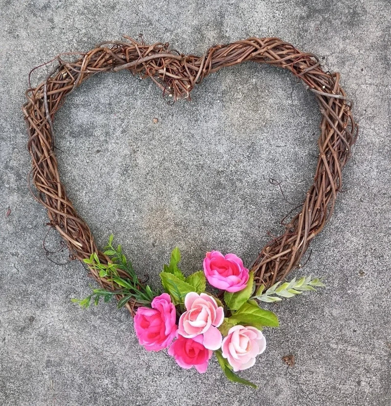 Heart-shaped grapevine wreath with pink artificial peony flowers and green leaves